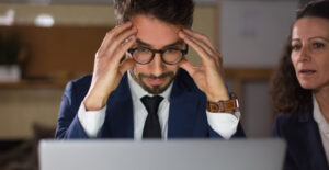 Empreendedor preocupado diante do computador ilustrando 5 erros que o MEI comete e que podem custar caro ao negócio