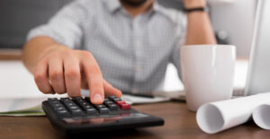 Empresário calculando custos em mesa de trabalho sobre planejamento tributário para pequenas empresas