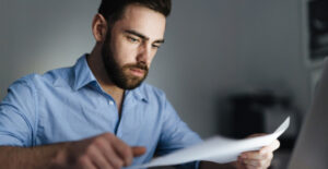 Síndico analisando documentos sobre obrigações fiscais do condomínio em rotina de gestão